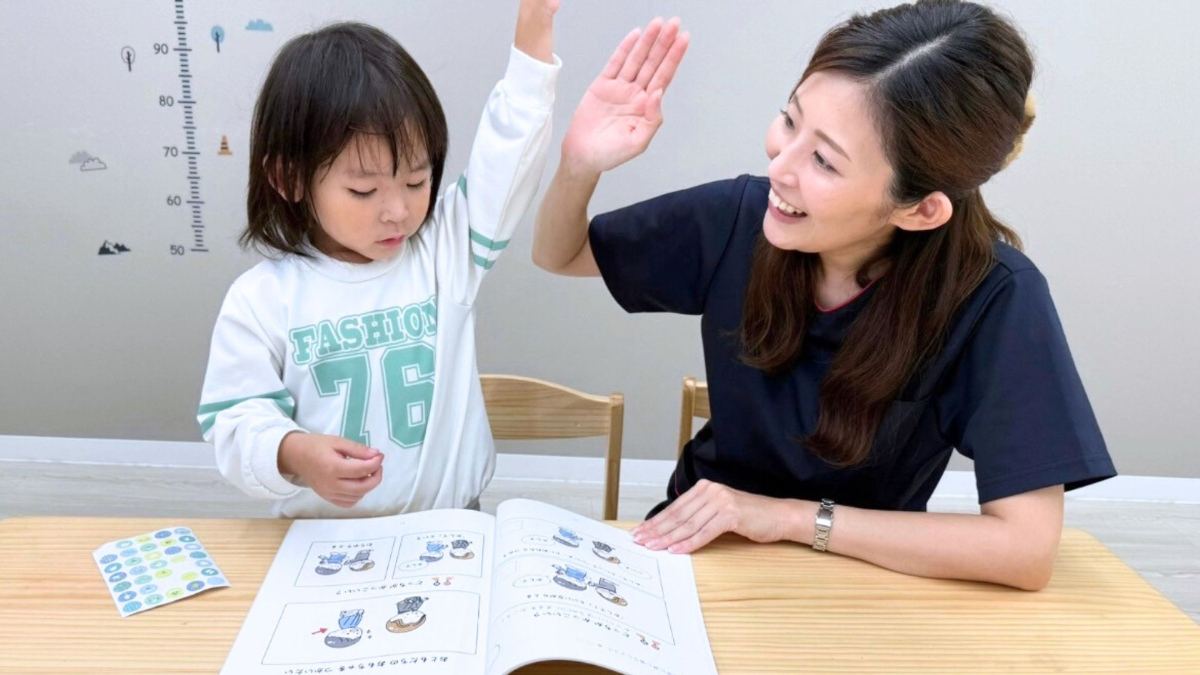 子供の反応を優しく見守りながら、サポートする療育スタッフ